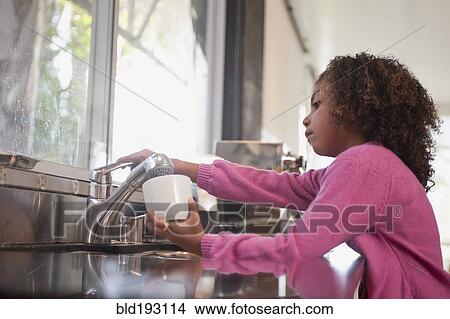 Picture - Mixed race girl washing dishes. Fotosearch
