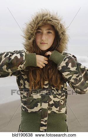 Stock Photo - Mixed Race girl wearing jacket at beach. Fotosearch