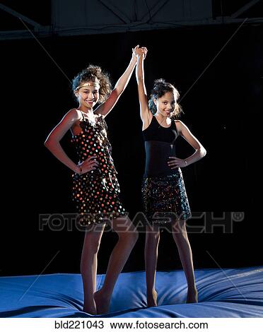 Stock Image - Mixed race girls cheering on padding. Fotosearch