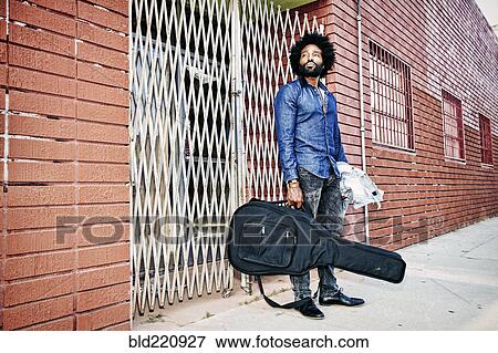 Mixed race man carrying guitar outdoors View Large Photo Image Stock Photo - Mixed race man carrying guitar outdoors. Fotosearch