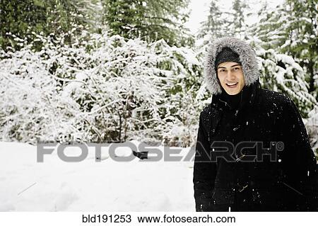 Mixed race man in hooded coat outdoors in snowfall View Large Photo Image Stock Image - Mixed race man in hooded coat outdoors in snowfall. Fotosearch