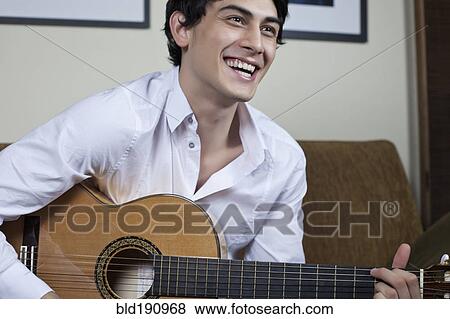 Stock Photo - Mixed race man playing guitar. Fotosearch