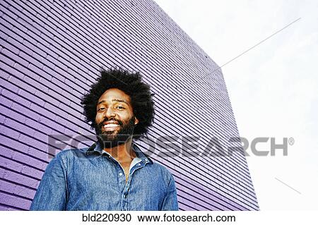 Stock Image - Mixed race man smiling outdoors. Fotosearch