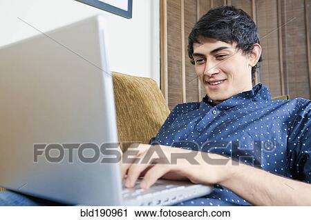 Stock Image - Mixed race man typing on laptop. Fotosearch