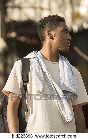 Mixed Race man with backpack and shirt draped over shoulders View Large Photo Image Stock Image - Mixed Race man with backpack and shirt draped over shoulders. Fotosearch