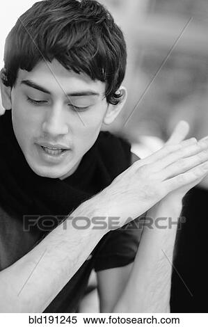 Stock Photography - Mixed race man with hands clasped. Fotosearch