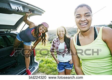 Mixed Race mother and daughters at hatch of car laughing View Large Photo Image Stock Image - Mixed Race mother and daughters at hatch of car laughing. Fotosearch