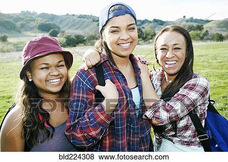 Mixed Race mother and daughters backpacking in field View Large Photo Image Stock Photo - Mixed Race mother and daughters backpacking in field. Fotosearch