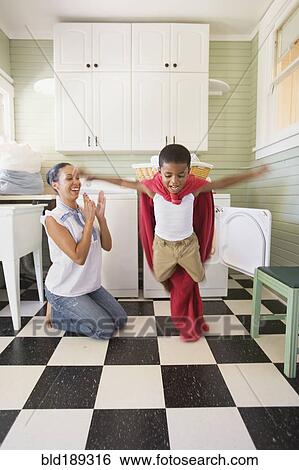 Mixed race mother and son playing with laundry View Large Photo Image Stock Photograph - Mixed race mother and son playing with laundry. Fotosearch