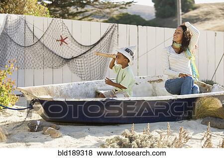 Mixed race mother and son pretending to sail in a boat View Large Photo Image Stock Photo - Mixed race mother and son pretending to sail in a boat. Fotosearch