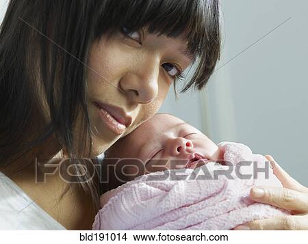 Mixed race mother cuddling newborn baby View Large Photo Image Picture - Mixed race mother cuddling newborn baby. Fotosearch