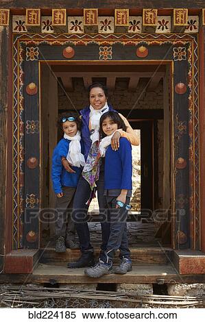 Stock Photography - Mixed Race mother hugging sons in doorway. Fotosearch