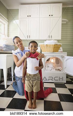 Picture - Mixed race mother tying towel to son. Fotosearch