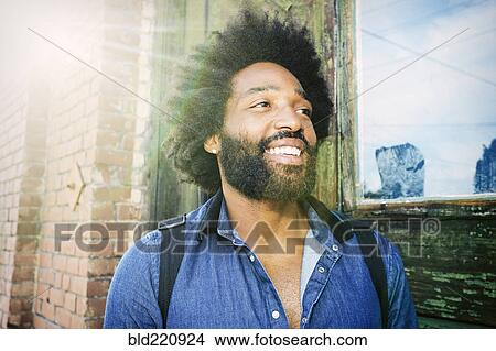 Picture - Mixed race musician carrying guitar outdoors. Fotosearch