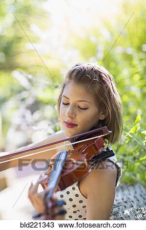 Stock Image - Mixed race musician playing violin outdoors. Fotosearch