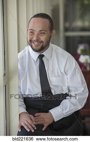 Mixed race server with down syndrome smiling in restaurant View Large Photo Image Stock Photograph - Mixed race server with down syndrome smiling in restaurant. Fotosearch