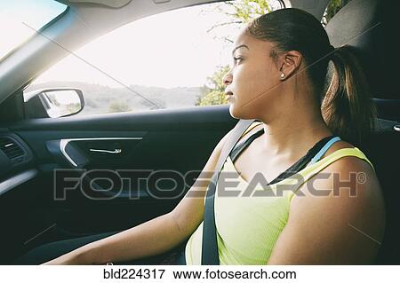 Stock Photo - Mixed Race woman daydreaming in car. Fotosearch