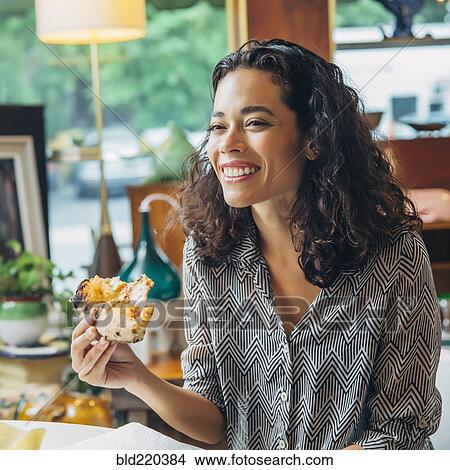 Mixed race woman eating in cafe View Large Photo Image Picture - Mixed race woman eating in cafe. Fotosearch