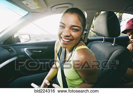 Stock Photograph - Mixed Race woman laughing in car. Fotosearch