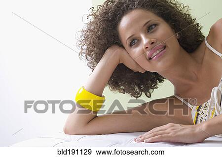 Mixed race woman laying on sofa View Large Photo Image Stock Photo - Mixed race woman laying on sofa. Fotosearch