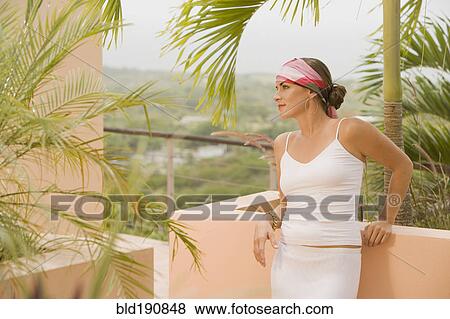 Mixed race woman leaning against balcony wall View Large Photo Image Stock Photo - Mixed race woman leaning against balcony wall. Fotosearch