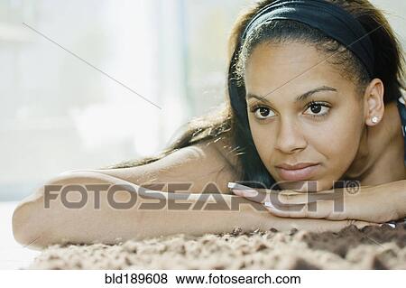Mixed race woman relaxing on rug View Large Photo Image Stock Photo - Mixed race woman relaxing on rug. Fotosearch