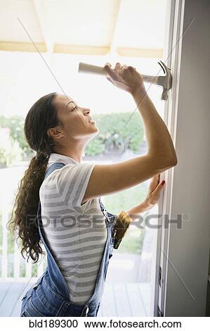 Mixed race woman removing nail from doorway View Large Photo Image Stock Image - Mixed race woman removing nail from doorway. Fotosearch