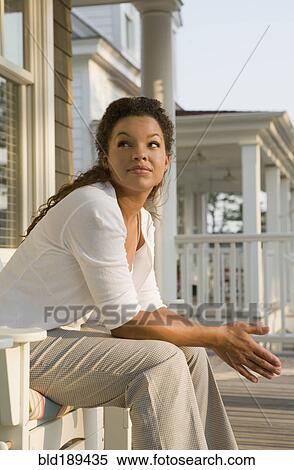 Mixed race woman sitting on porch View Large Photo Image Stock Photography - Mixed race woman sitting on porch. Fotosearch