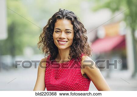 Mixed race woman smiling in city View Large Photo Image Stock Photo - Mixed race woman smiling in city. Fotosearch