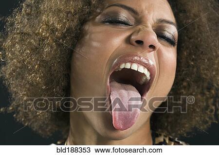 Stock Image - Mixed Race woman sticking out tongue. Fotosearch