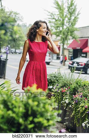 Mixed race woman talking on cell phone on city sidewalk View Large Photo Image Stock Image - Mixed race woman talking on cell phone on city sidewalk. Fotosearch