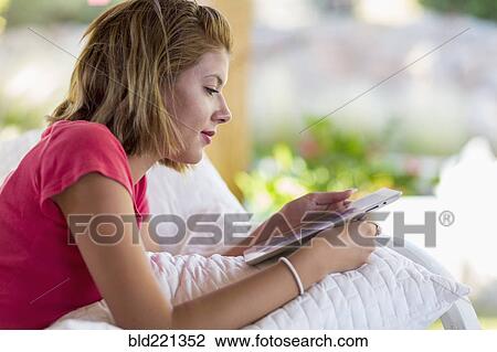 Stock Image - Mixed race woman using digital tablet. Fotosearch