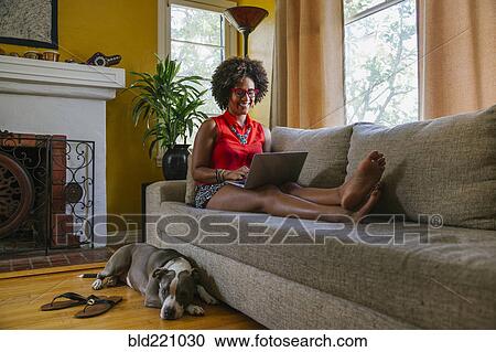 Mixed race woman using laptop on sofa View Large Photo Image Stock Image - Mixed race woman using laptop on sofa. Fotosearch
