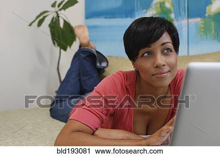 Stock Image - Mixed race woman using laptop. Fotosearch