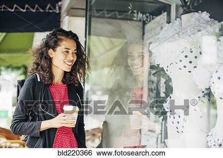 Mixed race woman window shopping outside store View Large Photo Image Stock Photograph - Mixed race woman window shopping outside store. Fotosearch