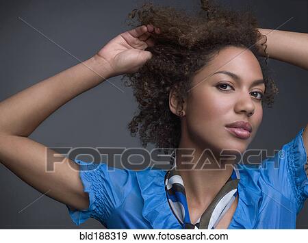 Stock Photo - Mixed Race woman with hands in hair. Fotosearch