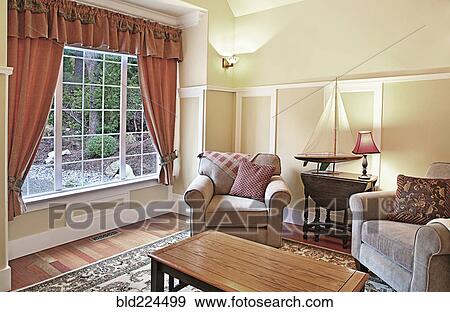 Stock Photo - Model sailboat in livingroom with armchairs. Fotosearch