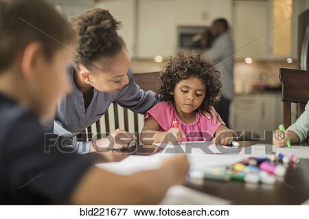 Stock Photo - Mother and children drawing in kitchen. Fotosearch