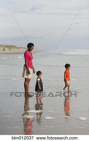 Stock Photo - Mother and children enjoying beach together. Fotosearch