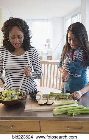 Mother and daughter chopping vegetables for salad View Large Photo Image Picture - Mother and daughter chopping vegetables for salad. Fotosearch