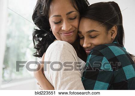 Stock Image - Mother and daughter hugging. Fotosearch