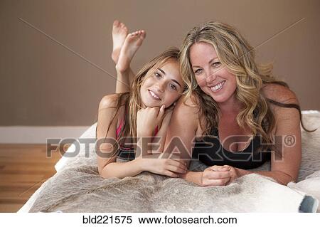 Mother and daughter laying on bed View Large Photo Image Stock Photography - Mother and daughter laying on bed. Fotosearch