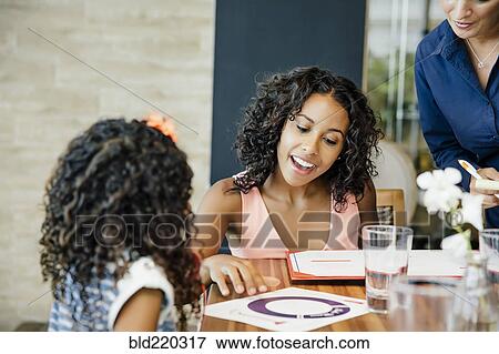 Mother and daughter reading menu restaurant table View Large Photo Image Stock Photo - Mother and daughter reading menu restaurant table. Fotosearch