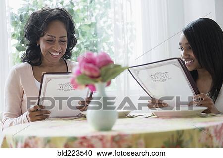 Mother and daughter reading menus in restaurant View Large Photo Image Stock Image - Mother and daughter reading menus in restaurant. Fotosearch