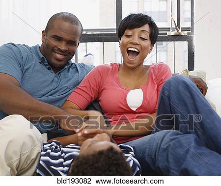 Mother and father tickling son View Large Photo Image Stock Image - Mother and father tickling son. Fotosearch
