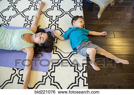 Stock Photograph - Mother and son laying on floor. Fotosearch