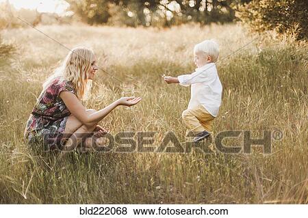 Stock Photo - Mother and son playing in field. Fotosearch