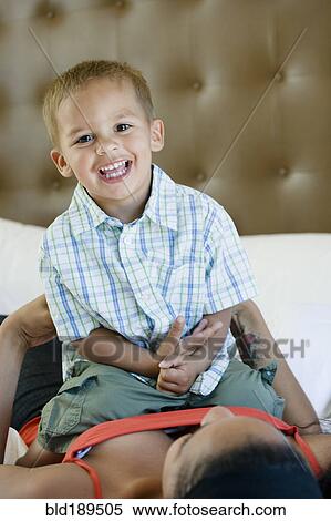 Stock Photography - Mother and son playing on bed. Fotosearch