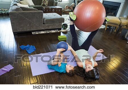 Stock Image - Mother and son playing with exercise ball. Fotosearch
