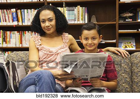 Stock Photo - Mother and son reading newspapers in libraries. Fotosearch